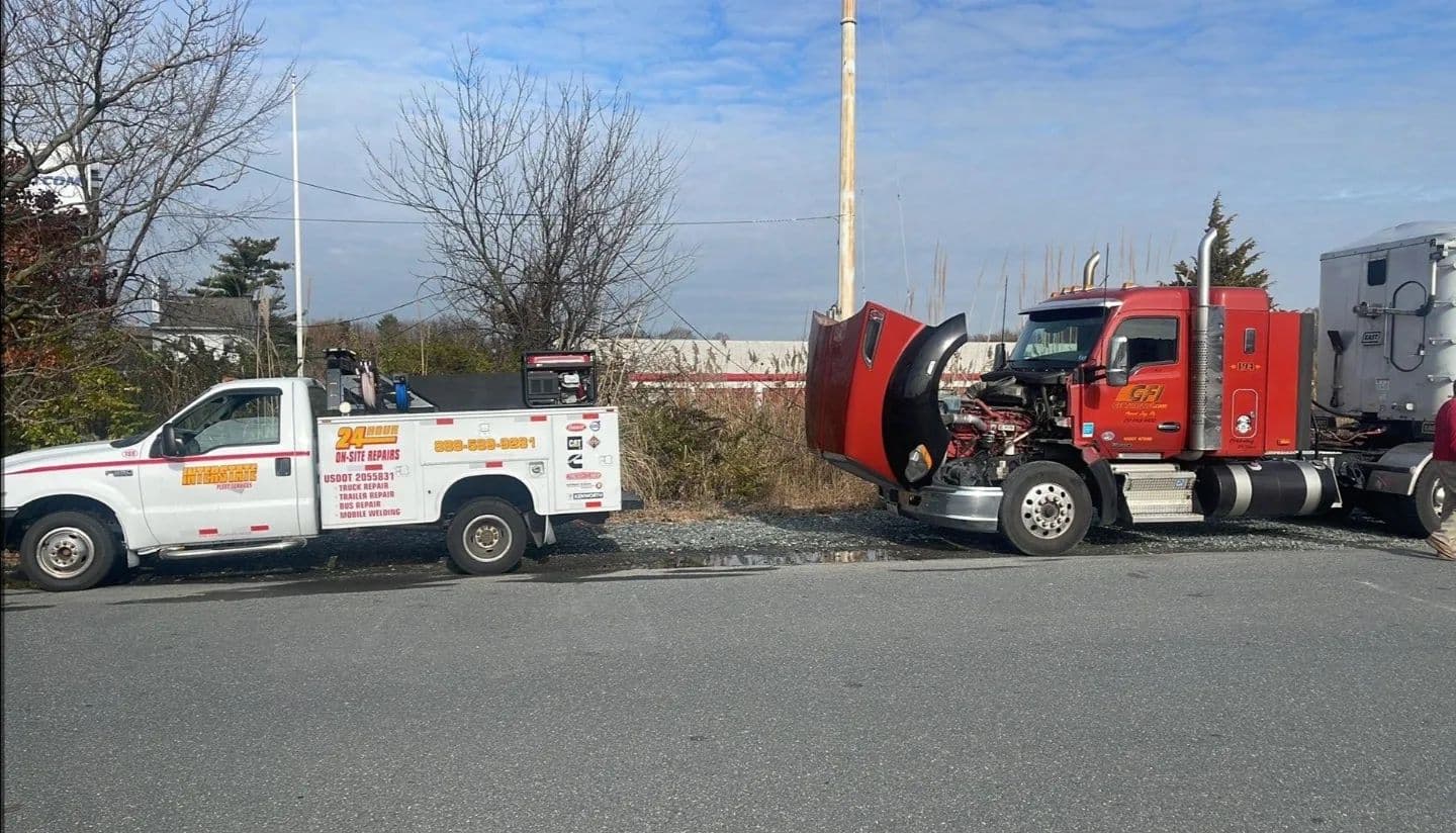 Interstate Fleet Services truck stopped roadside next to a tractor-trailer